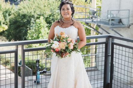Bride in straplass lace wedding dress with peach bouquet before Vietnamese-American wedding at the Bridge Building, a downtown Nashville wedding venue