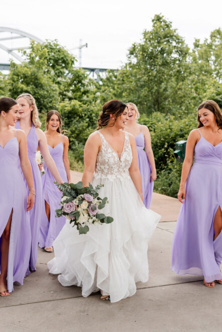 Carissa Walking With Bridesmaids Dressed in Lavender Dresses Outside of Venue