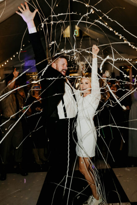 Haley and Andrew celebrate with white streamers after wedding day