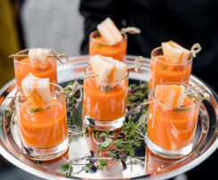 Mini tomato soup shooters with small grilled cheeses on silver tray