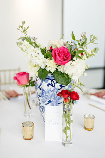 Blue willow China centerpiece with white flowers and red roses for Chinese-American wedding reception at the Bridge Building, a downtown Nashville wedding venue