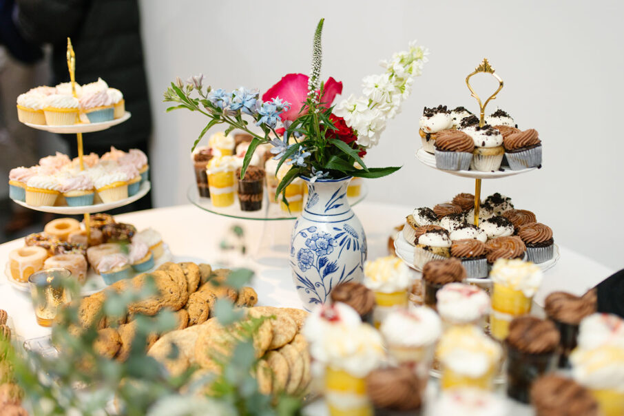 Dessert table with an assortment of sweets such as cupcakes, cookies, donuts, and dessert shooters with a chinoiserie vase centerpiece at the Bridge Building, a downtown Nashville wedding venue