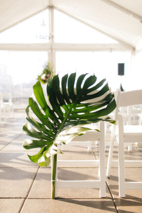 Large tropical palm leaf as aisle marker for tropical-inspired wedding at the Bridge Building, a downtown Nashville wedding venue